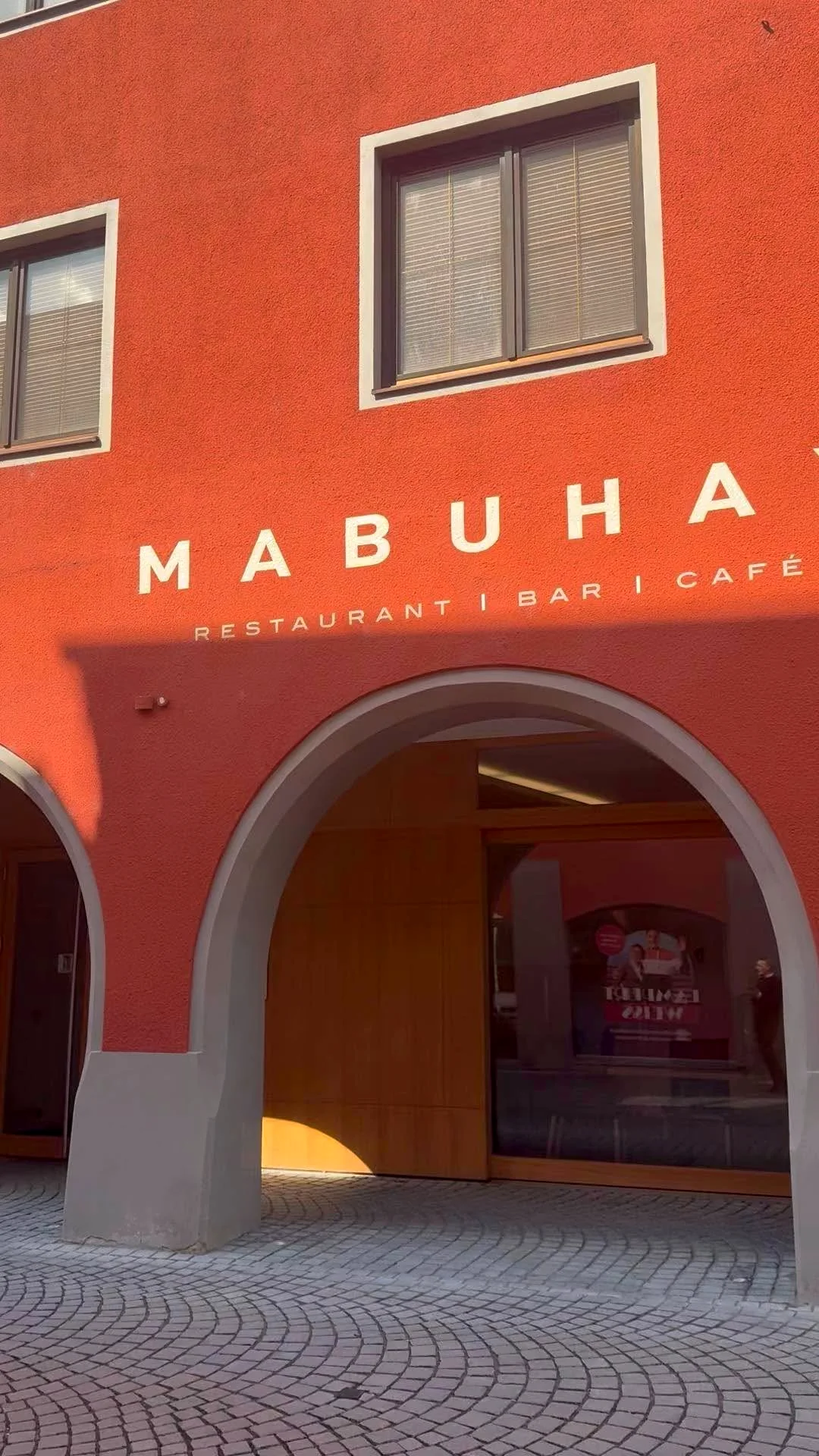 Die rote Fassade des Mabuhay mit dem Rundbogen der Arkaden in der Rathausgasse Bludenz