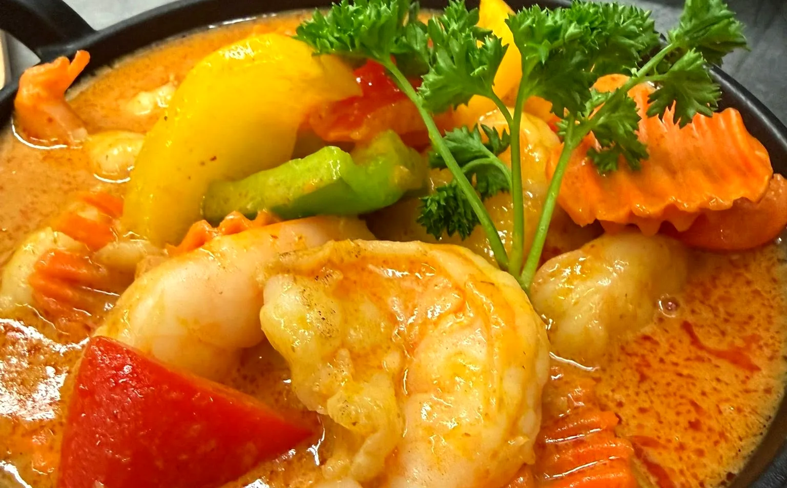 Garnelen Curry mit gelber Currysauce, Paprika und Karotten in der Gusseisenpfanne
