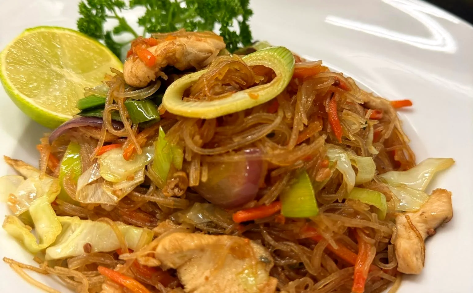 Pancit Bihon: gebratene Reisnudeln mit Hühnerfleisch, Gemüse und Limette