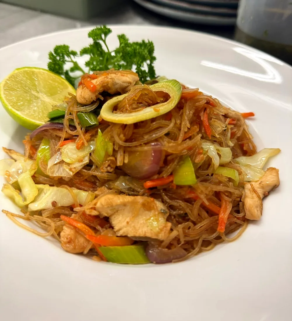 Pancit Bihon mit Hühnerfleisch, Kraut, Karotten und Limette